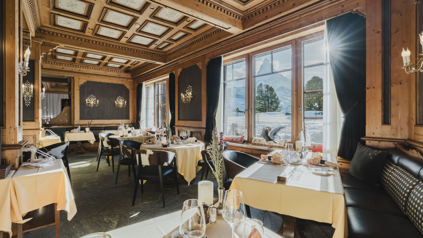 Salle panoramique du Restaurant Alexandre baignée de lumière en hiver au Riffelalp Resort 2222m à Zermatt, hôtel de luxe 5 étoiles dans les Alpes suisses proposant une cuisine régionale et méditerranéenne dans une atmosphère romantique