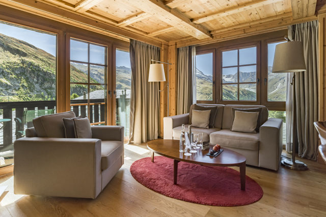 Salon confortable de la Monte Rosa Suite au Riffelalp Resort 2222m à Zermatt, idéal pour un séjour de luxe au cœur des Alpes suisses avec vue sur les montagnes.