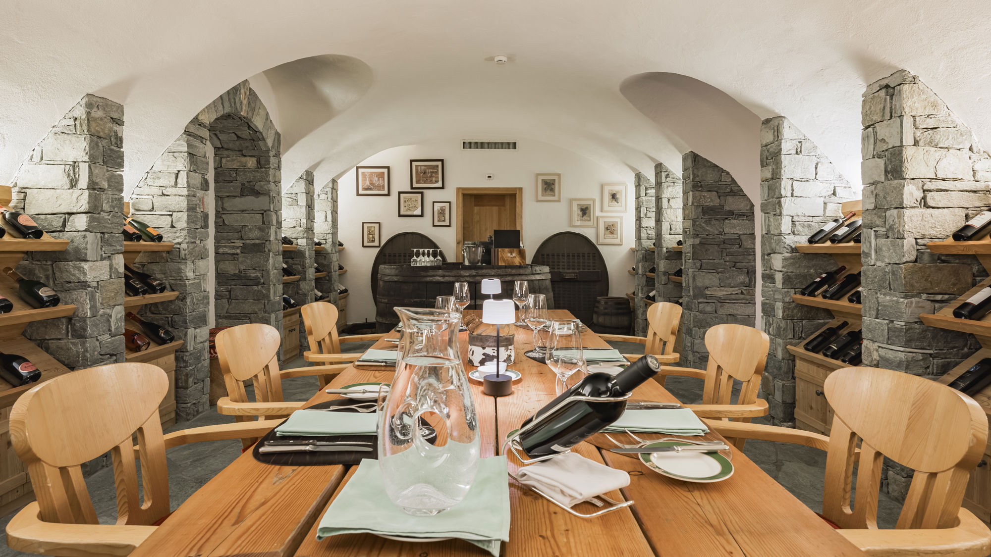 Vue d'ensemble de la Vinothek du Riffelalp Resort 2222m au-dessus de Zermatt, hôtel de luxe 5 étoiles dans les Alpes suisses, où les voûtes en pierre, les tables de dégustation et une sélection de grands crus créent un cadre élégant dédié à l'art du vin.