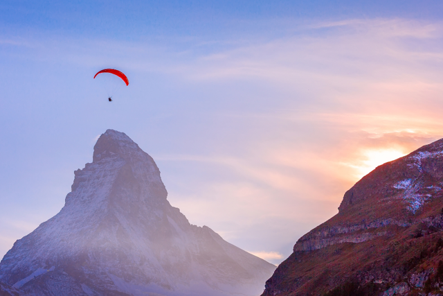 Vol en parapente au-dessus des paysages alpins de Zermatt avec une vue spectaculaire sur le Cervin (Matterhorn), une expérience inoubliable à vivre lors de votre séjour au Riffelalp Resort 2222m.