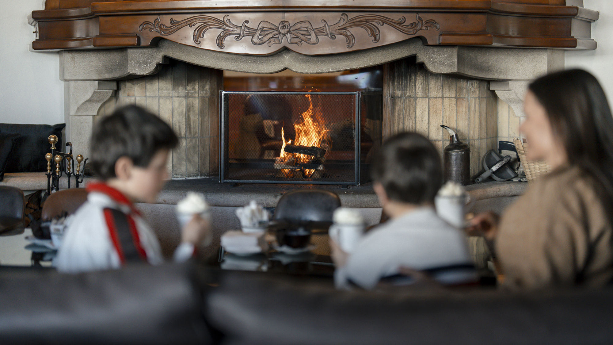 Salon avec cheminée du Bar 2222m au Riffelalp Resort 2222m au-dessus de Zermatt, hôtel de luxe 5 étoiles dans les Alpes suisses invitant à la détente dans une ambiance chaleureuse en famille après une journée sur les pistes.