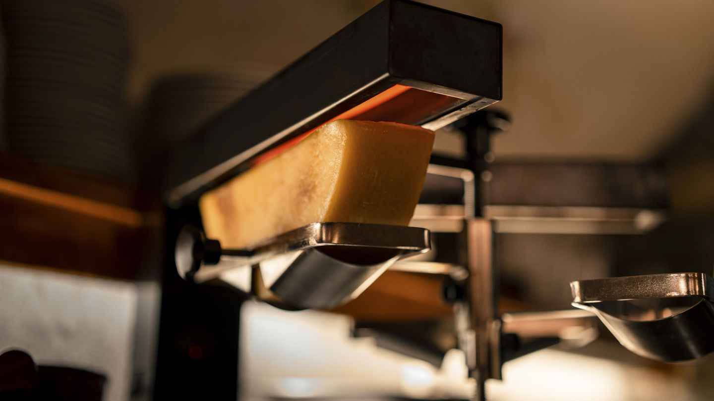 Four à raclette traditionnel du Restaurant Walliserkeller au Riffelalp Resort 2222m à Zermatt, hôtel de luxe 5 étoiles dans les Alpes suisses illustrant le savoir-faire de la cuisine valaisanne en hiver.