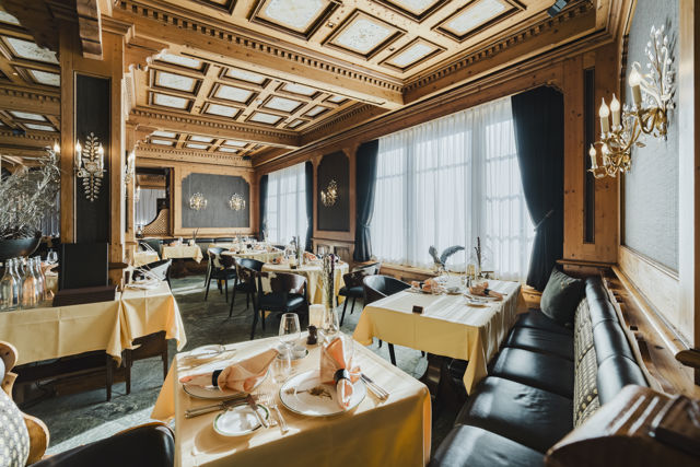 Salle en boiseries du Restaurant Alexandre en hiver au Riffelalp Resort 2222m à Zermatt, hôtel de luxe 5 étoiles dans les Alpes suisses mêlant romantisme alpin, service attentionné et gastronomie inspirée des montagnes et de la Méditerranée.