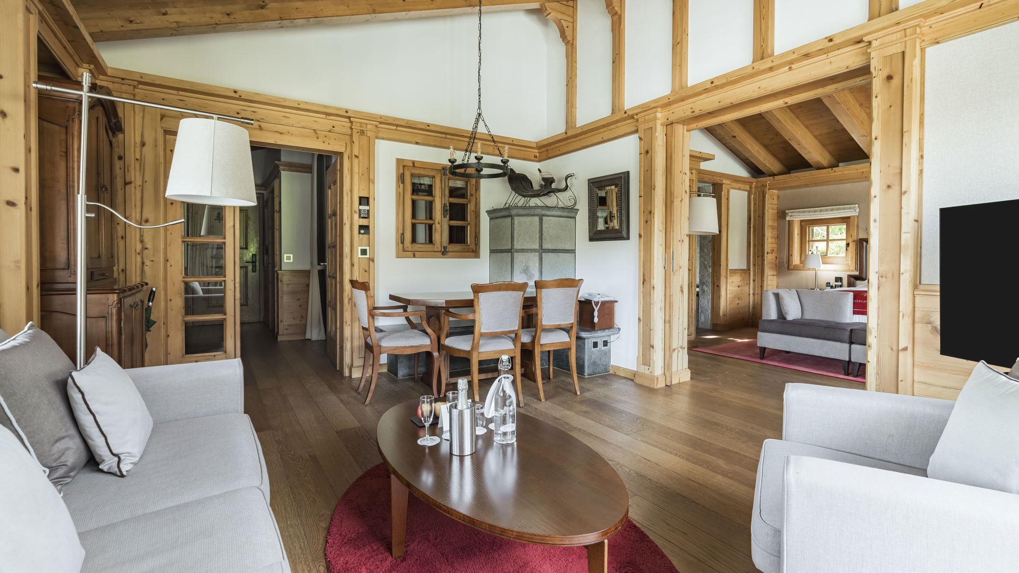 Vue d'ensemble du salon de la Monte Rosa Suite au Riffelalp Resort 2222m à Zermatt, suite de luxe de 75 m² avec mobilier raffiné, lumière naturelle et panorama sur les Alpes suisses.