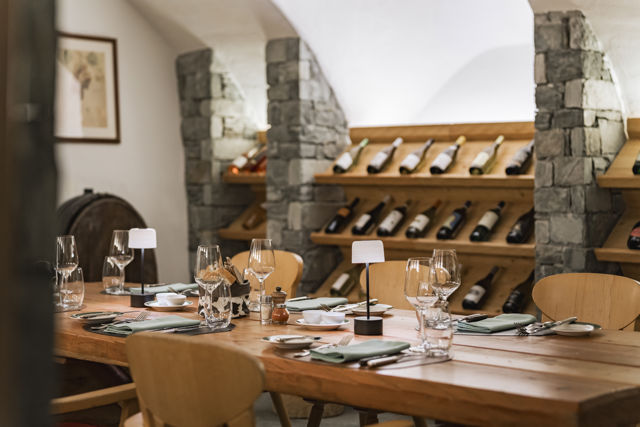 Vinothek du Riffelalp Resort 2222m au-dessus de Zermatt, hôtel de luxe 5 étoiles dans les Alpes suisses, avec ses casiers en bois garnis de grands crus, ses voûtes en pierre et son espace de dégustation à l'ambiance élégante et chaleureuse.
