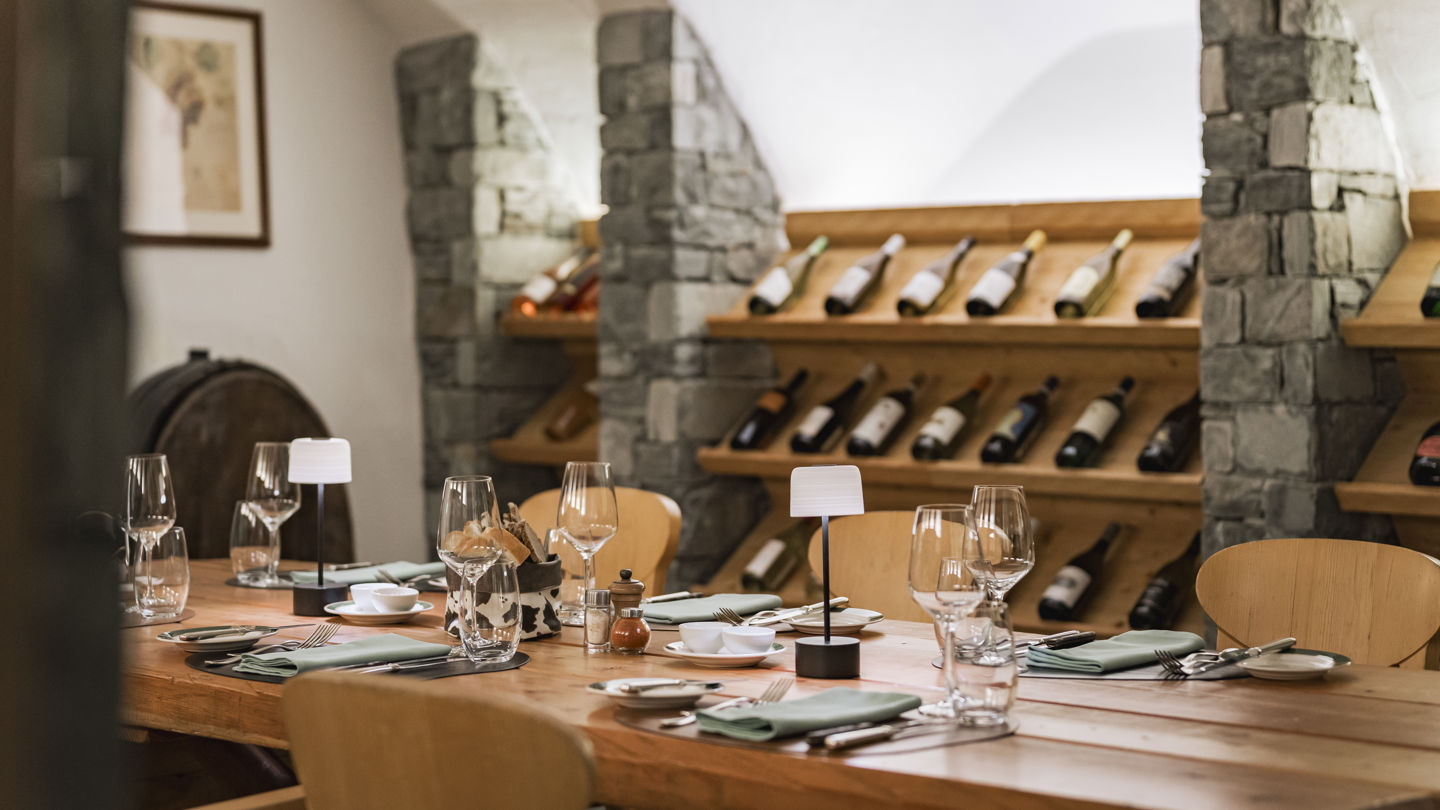 Vinothek du Riffelalp Resort 2222m au-dessus de Zermatt, hôtel de luxe 5 étoiles dans les Alpes suisses, avec ses casiers en bois garnis de grands crus, ses voûtes en pierre et son espace de dégustation à l'ambiance élégante et chaleureuse.
