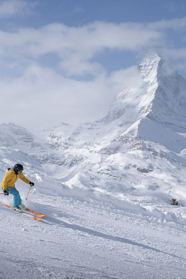 Skieur profitant des pistes enneigées avec panorama sur le Cervin près du Riffelalp Resort 2222m à Zermatt, hôtel de luxe 5 étoiles dans les Alpes suisses pour des vacances d'hiver, un séjour ski premium et des expériences de montagne exclusives.