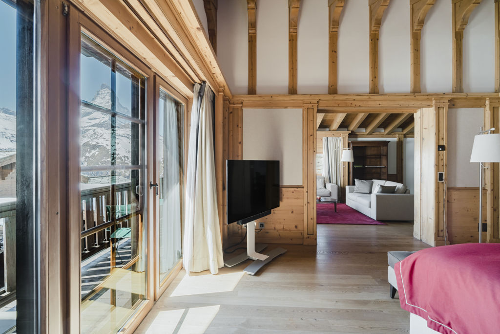 Suite Matterhorn avec chambre ouverte sur le salon, balcon et vue sur le Cervin enneigé au Riffelalp Resort 2222m.