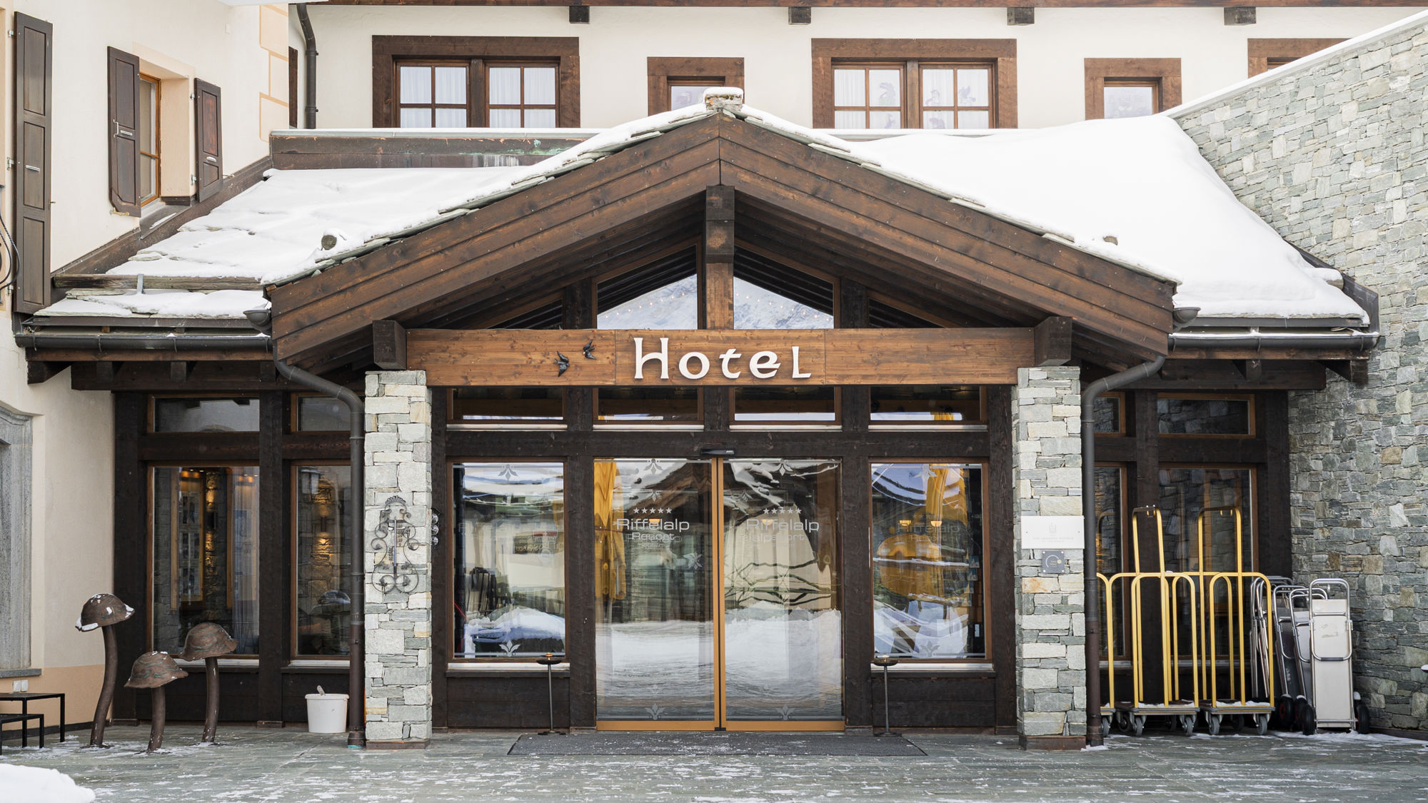 Entrée du Riffelalp Resort 2222m à Zermatt, hôtel de luxe 5 étoiles dans les Alpes suisses accueillant ses hôtes dans un cadre élégant, authentique et chaleureux au cœur des montagnes enneigées.