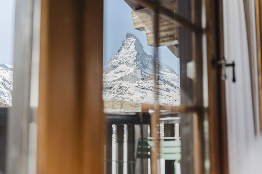 Vue sur le Cervin enneigé à travers les fenêtres en bois de la Suite Matterhorn au Riffelalp Resort 2222m à Zermatt.
