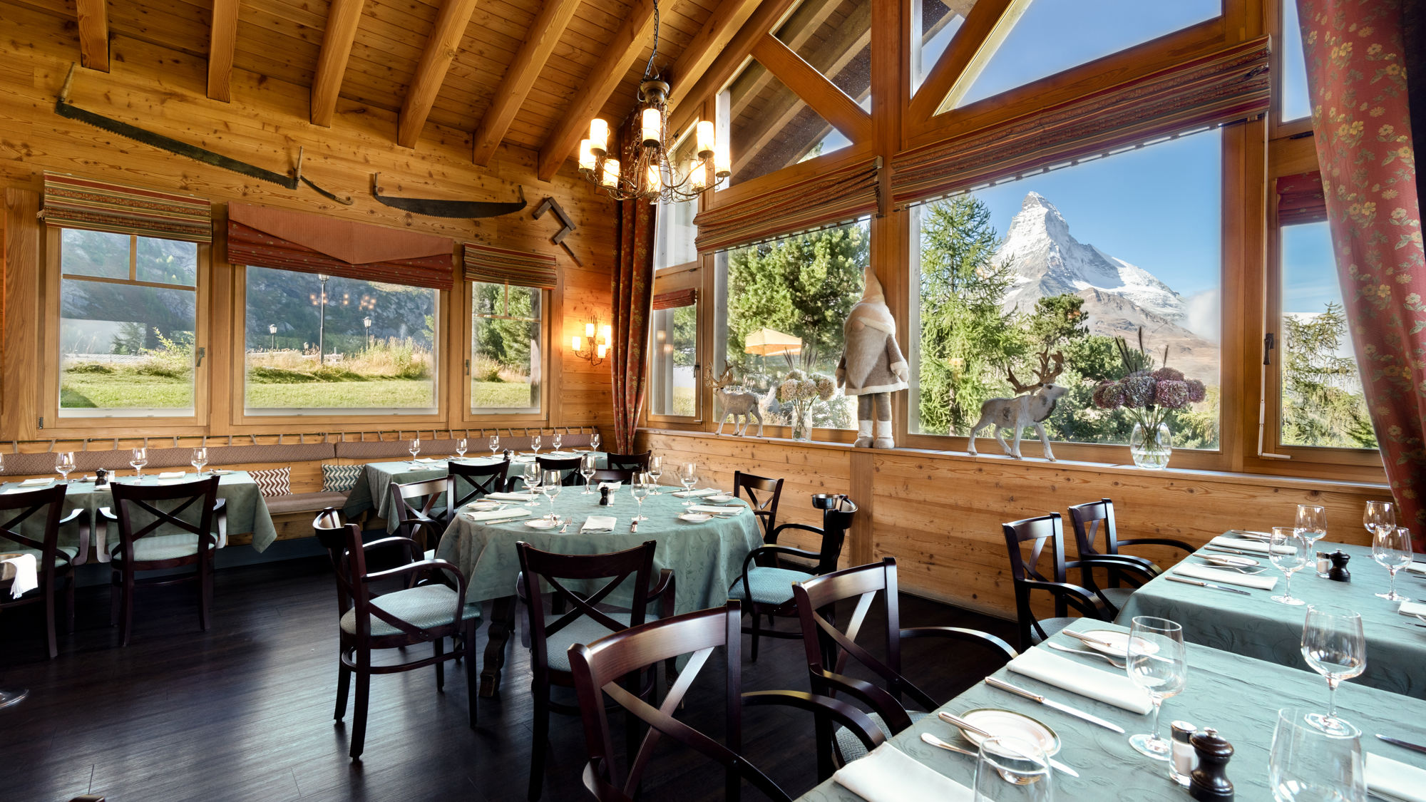 Salle panoramique du Ristorante Al Bosco au Riffelalp Resort 2222m au-dessus de Zermatt, hôtel de luxe 5 étoiles dans les Alpes suisses, offrant une cuisine italienne raffinée, des spécialités préparées avec des ingrédients alpins suisses et une vue exceptionnelle sur le Cervin.