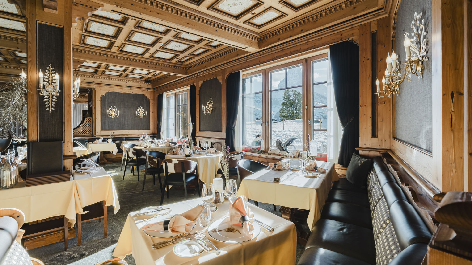 Salle du Restaurant Alexandre avec grandes baies vitrées ouvertes sur le paysage hivernal au Riffelalp Resort 2222m à Zermatt, hôtel de luxe 5 étoiles dans les Alpes suisses associant gastronomie, élégance alpine et panorama enneigé.