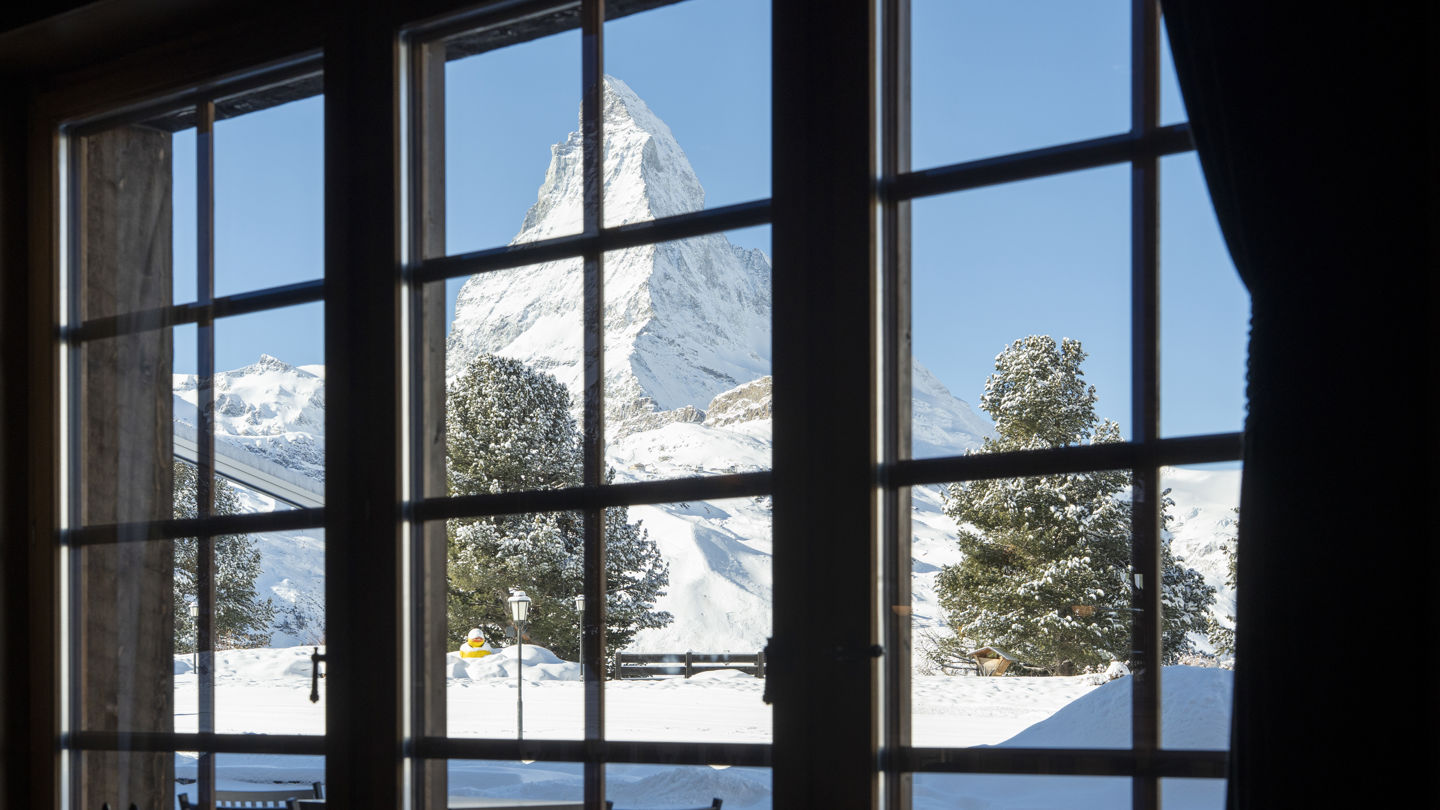 Vue sur le Cervin enneigé depuis les fenêtres du Bar 2222m au Riffelalp Resort 2222m à Zermatt, hôtel de luxe 5 étoiles dans les Alpes suisses offrant un panorama iconique sur le Matterhorn.
